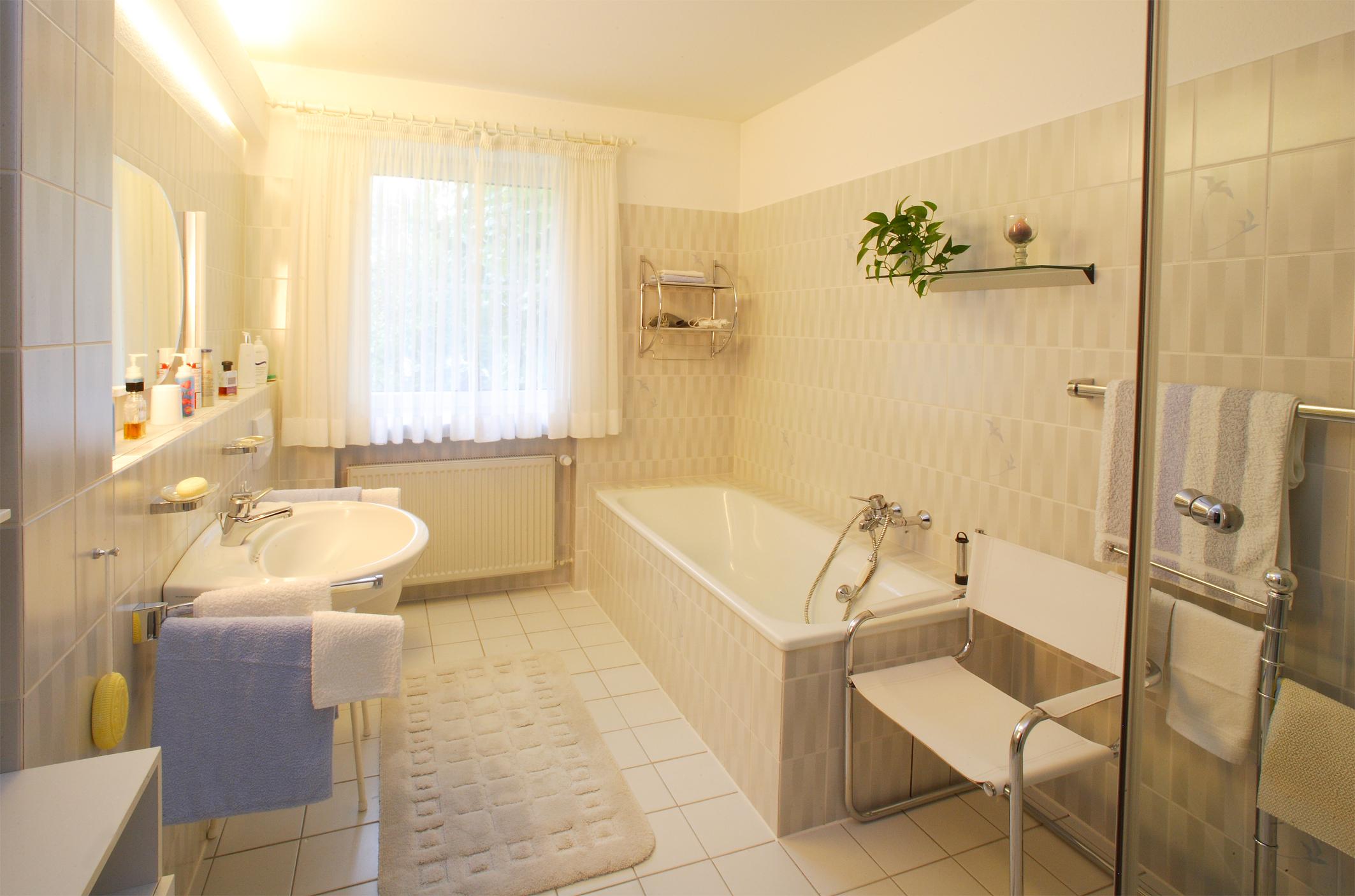 Behaglichkeit bietet das großzügige Badezimmer mit Wanne und separatem Duschbad