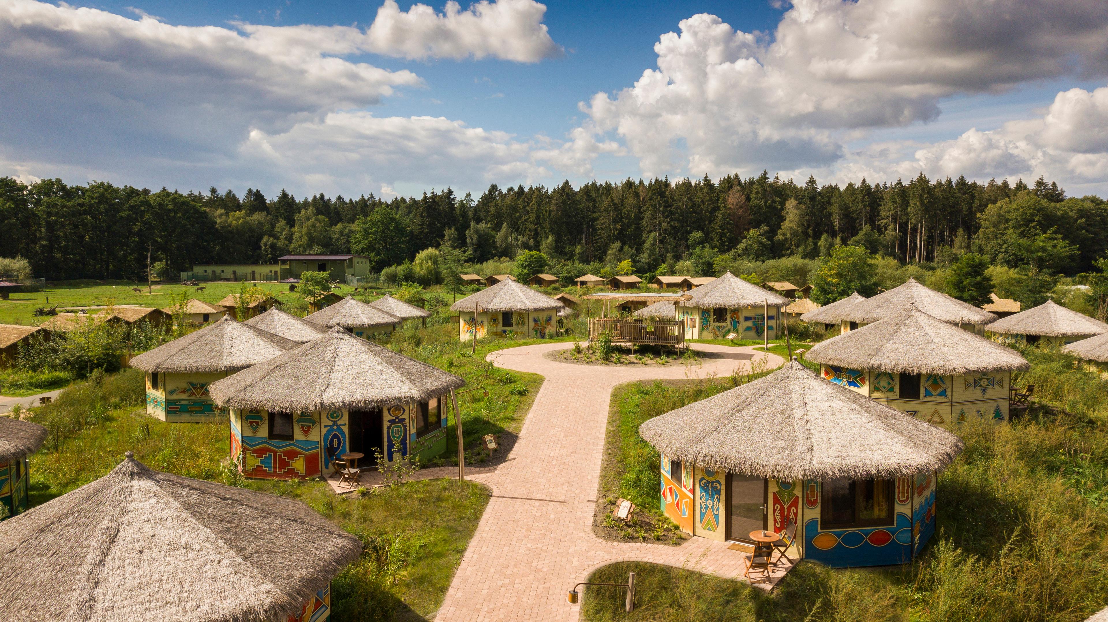Jambo-Lodges (runde Dächer) am Rande der Masai-Mara-Anlage im Serengeti-Park Hodenhagen
