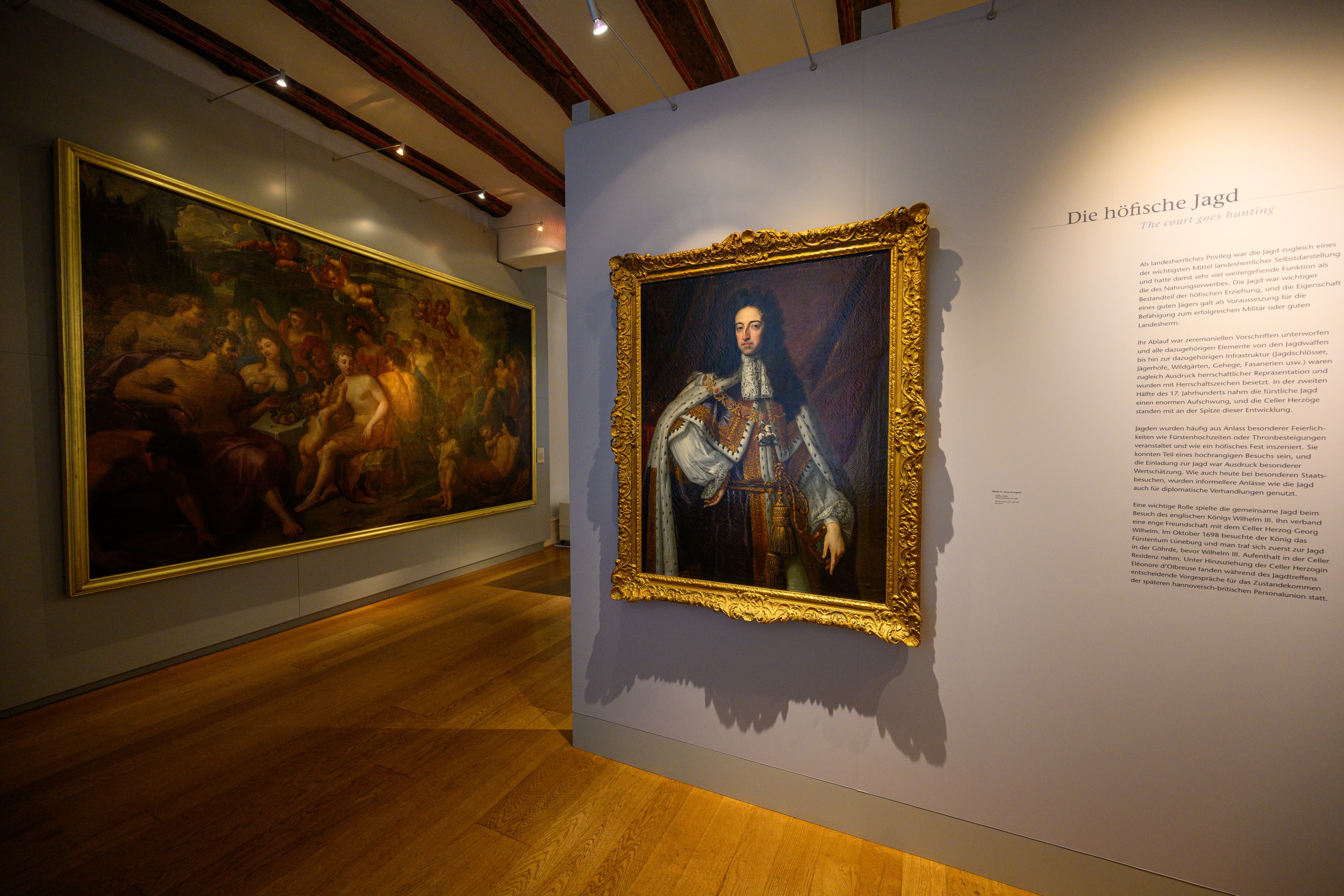 Galerieansicht im Residenzmuseum Celle mit Porträt und großformatigem Gemälde in Goldrahmen.