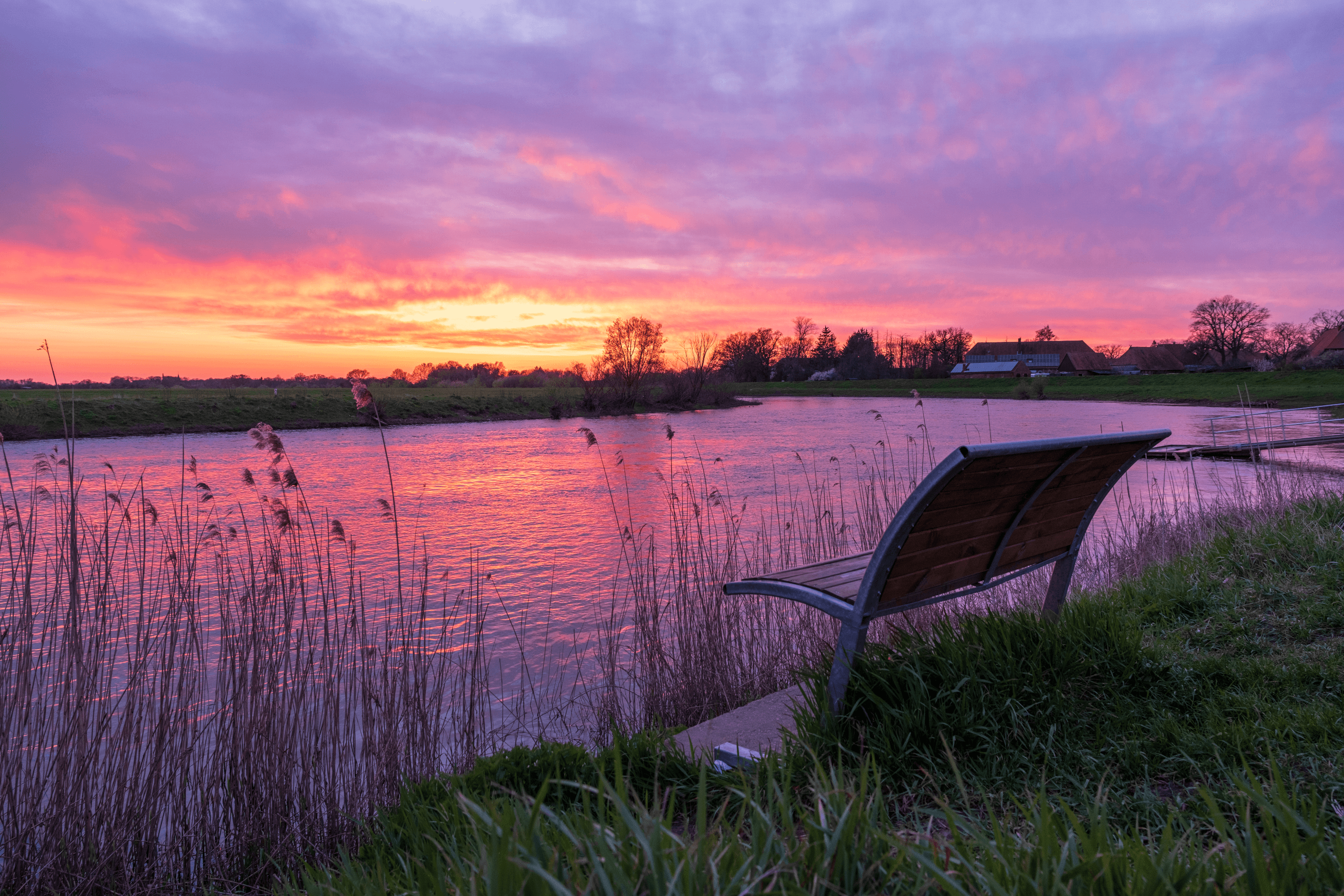 eine Bank an der Aller in Hodenhagen im Sonnenuntergang