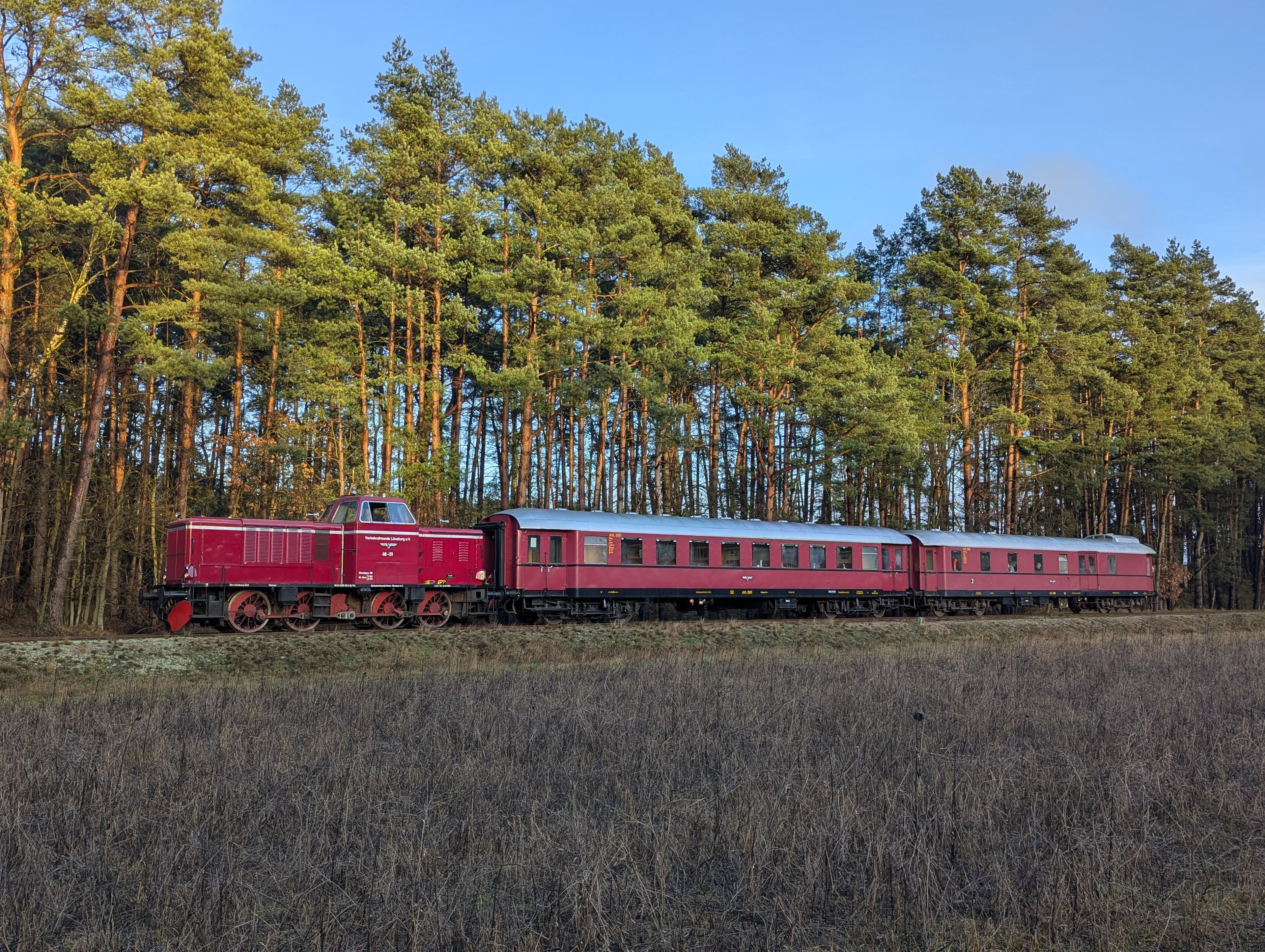 Rote Diesellokomotive mit zwei vierachsigen Reisezugwagen aus dem Jahre 1050