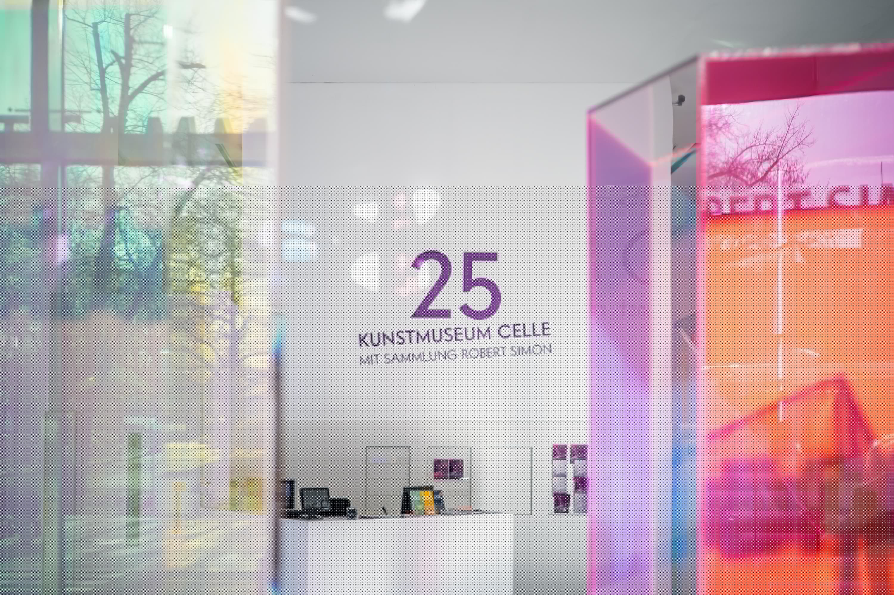 Empfang des Kunstmuseums Celle mit dem Logo 25 und farbigen, spiegelnden Glaselementen.