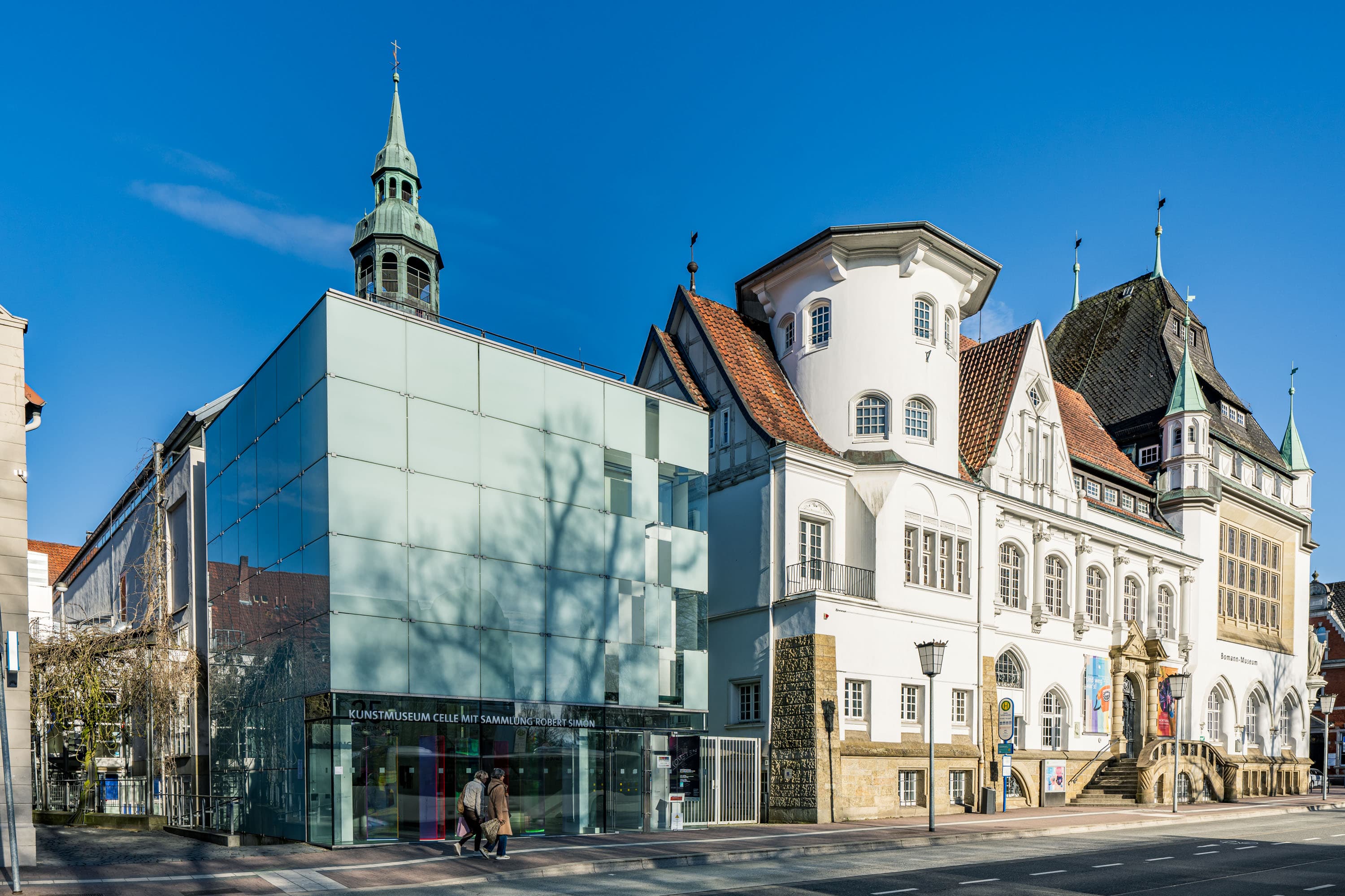 Moderne Glasfassade des Kunstmuseums Celle neben dem historischen Altbau des Bomann Museums an einem sonnigen Tag.