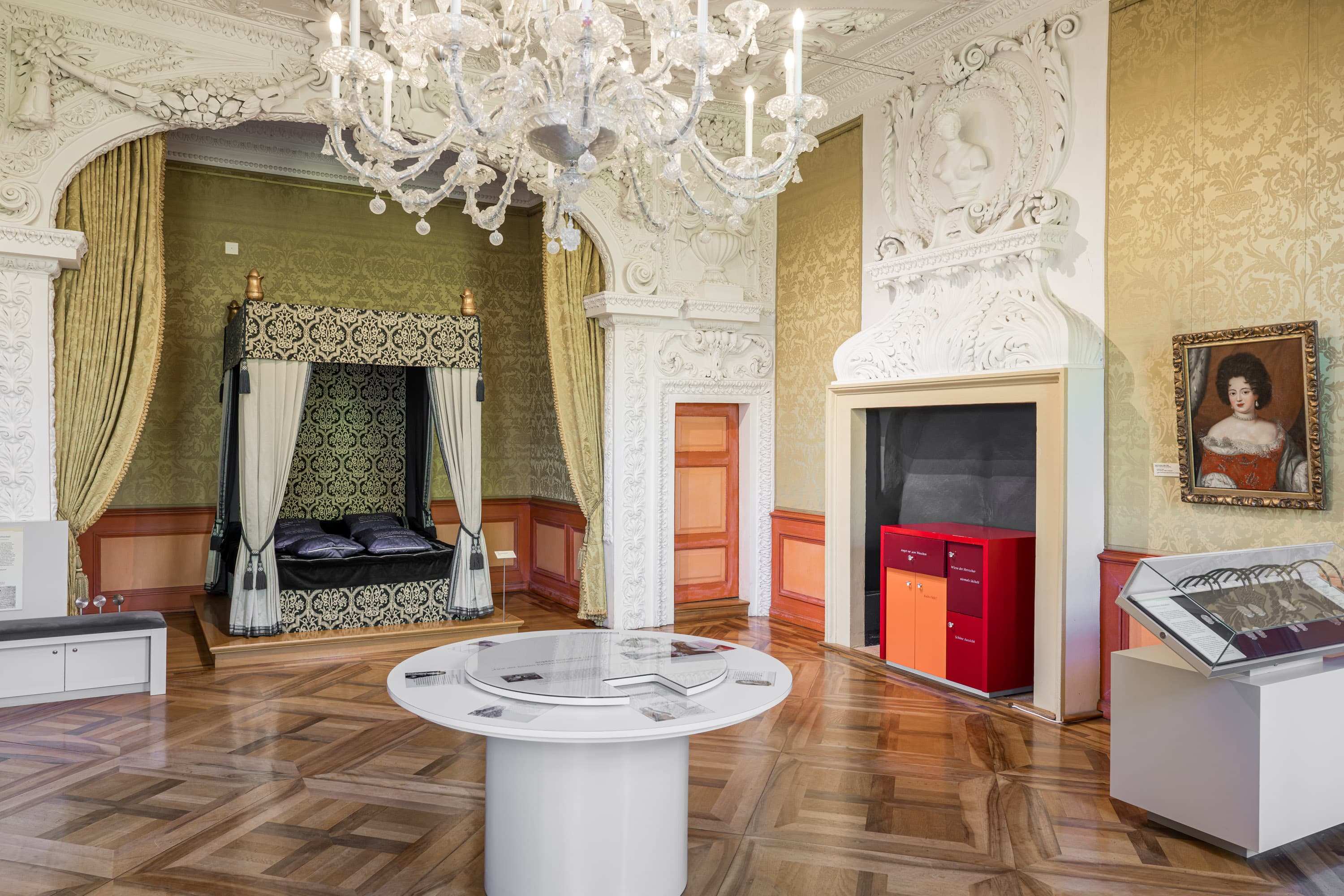 Herzögliches Barock-Gemach im Schloss Celle mit prunkvollem Himmelbett und Kristallleuchter.