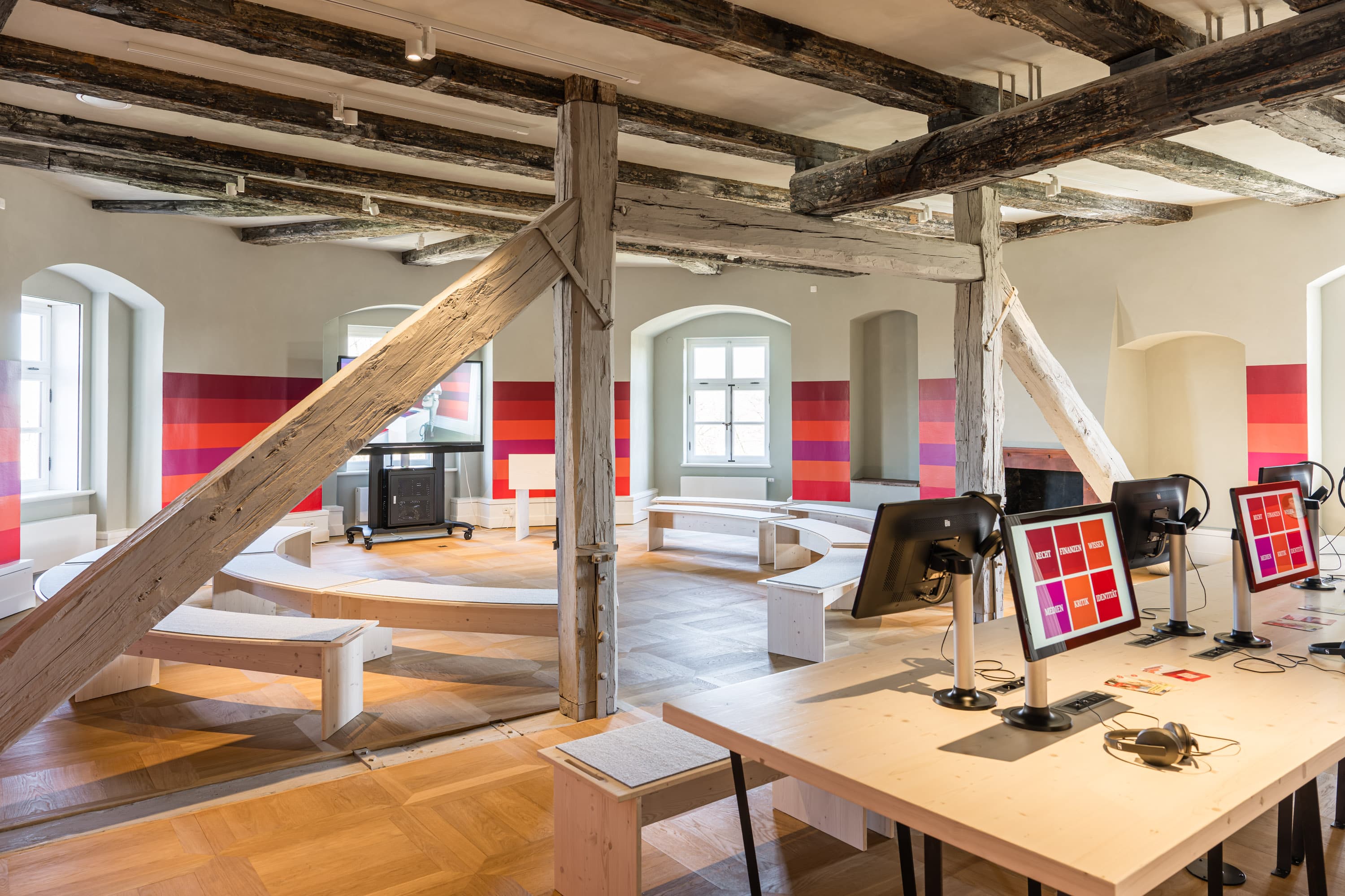 Heller Ausstellungsraum mit massiven Holzbalken und interaktiven Stationen im Residenzmuseum Celle.