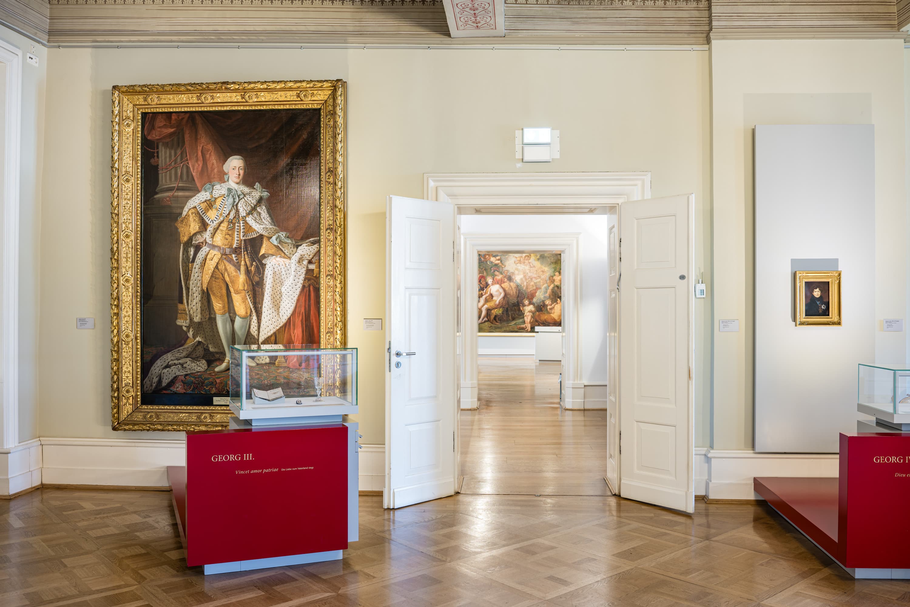 Raum der Herzöge im Residenzmuseum Celle mit Porträt von Georg III. und offenen Flügeltüren.