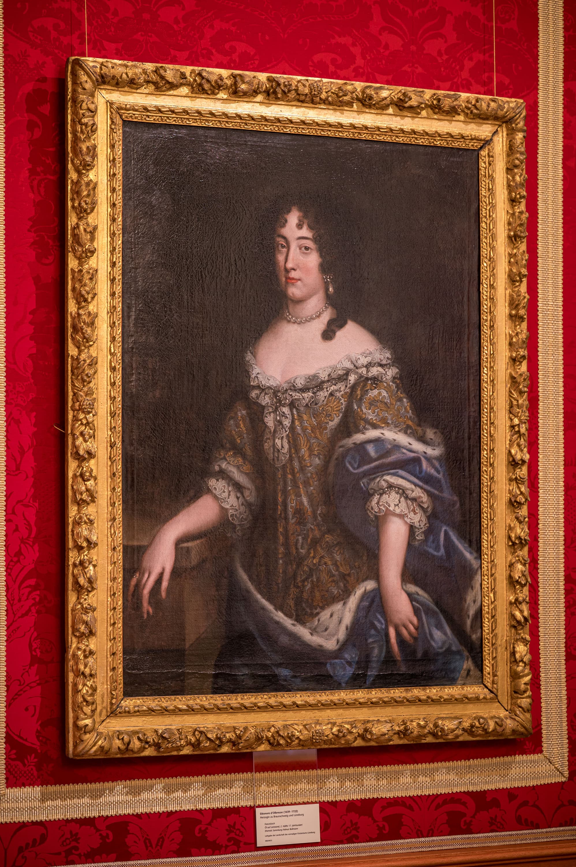 Porträt der Herzogin Eléonore d´Olbreuse in einem goldenen Rahmen an einer roten Wand im Schloss Celle.